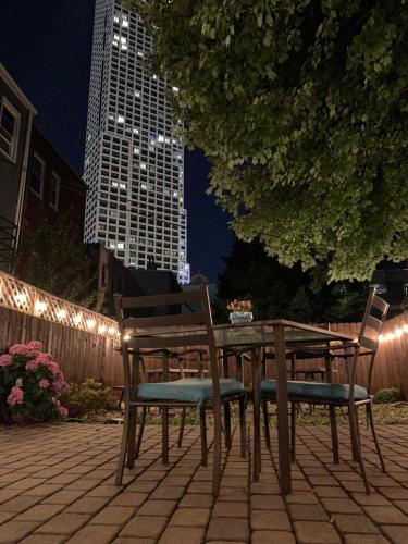 a wooden table and chairs sitting on a patio at night at Magnolia Stay near New York City in Jersey City