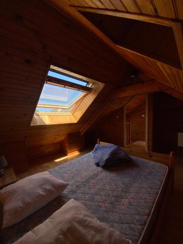 Cette chambre mansardée comprend un lit et une fenêtre. dans l'établissement Maison chaleureuse toute équipée pour vos vacances, à Saint-Quay-Portrieux