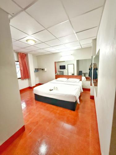 a large bedroom with a large white bed in it at Malee Guesthouse & Restaurant in Pattaya