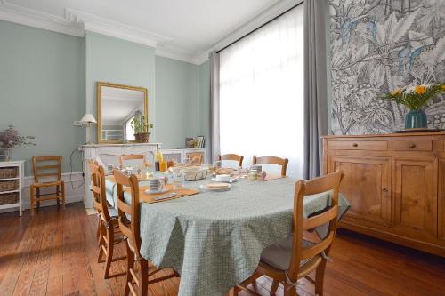 - une salle à manger avec une table, des chaises et un miroir dans l'établissement Les Chambres du 32, à Amiens