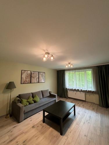 a living room with a couch and a coffee table at Coastline Flat in Liepāja
