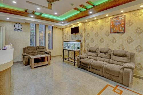 a living room with couches and a flat screen tv at Capital O Champion Lotus Near Mantri Square Mall in Bengaluru