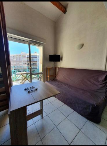 une chambre avec un lit, une table et une fenêtre dans l'établissement Studio rive droite, à Palavas-les-Flots