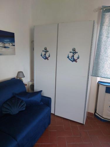 a living room with a blue couch and a refrigerator at I cavallucci marini in Lerici