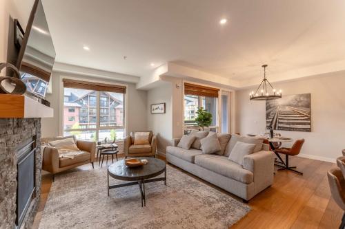 a living room with a couch and a table at Modern Mountain Oasis Top floor 2 level 2bd in Canmore