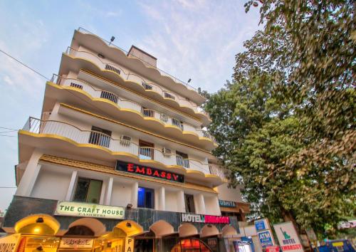 a tall building with a sign in front of it at Hotel O Embassy in Bodh Gaya