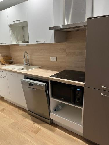 une cuisine avec un évier et une cuisinière four supérieur dans l'établissement Beau Duplex T3 de 66 m2 en plein centre de Montpellier Tout confort et bien situé, à Montpellier