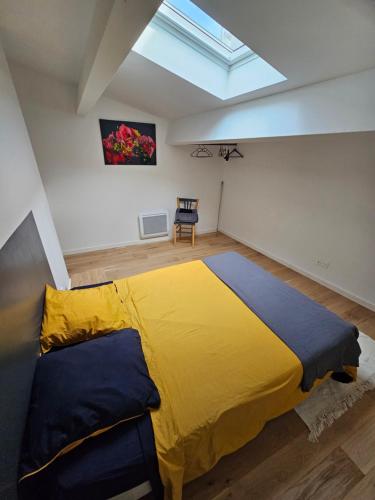 - une chambre avec un grand lit jaune et une chaise dans l'établissement Beau Duplex T3 de 66 m2 en plein centre de Montpellier Tout confort et bien situé, à Montpellier