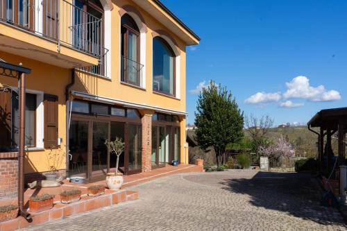 a yellow building with a walkway in front of it at Sorriso Dei Maestri in Calosso