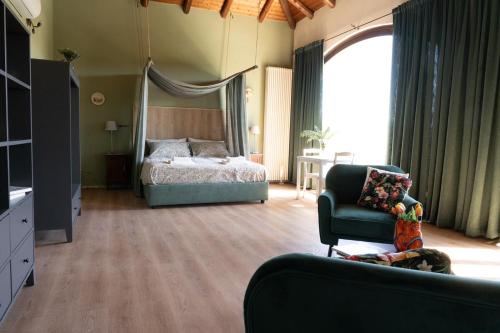 a bedroom with a bed and a couch and a chair at Sorriso Dei Maestri in Calosso
