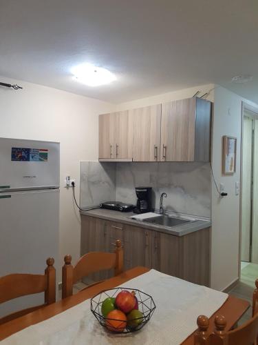a kitchen with a bowl of fruit on a table at Fyllou Apartment Asprovalta in Asprovalta