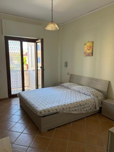 a bedroom with a bed and a large window at Casa Mare Verde in Casamicciola Terme