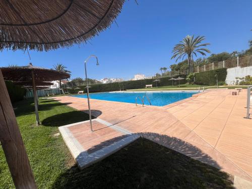 トレビエハにあるBright 2-Bedroom Holiday Home with Pool Access in Torreviejaの傘付きのスイミングプール、