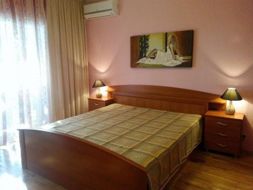 a bedroom with a bed and two lamps and a window at Apartment Sofia in Sutomore