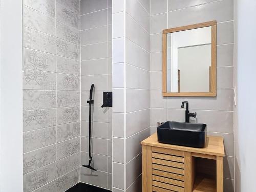 a bathroom with a black sink and a mirror at La Landaise moderne in Lugos
