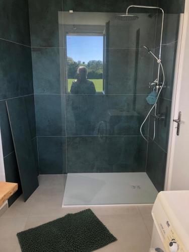 une salle de bain avec douche avec un homme à la fenêtre dans l'établissement Maison familiale à la campagne, à Cassagne