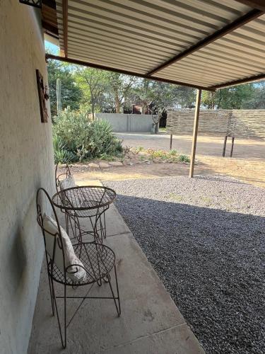 a patio with two chairs and a table under awning at The Stables in Ghanzi