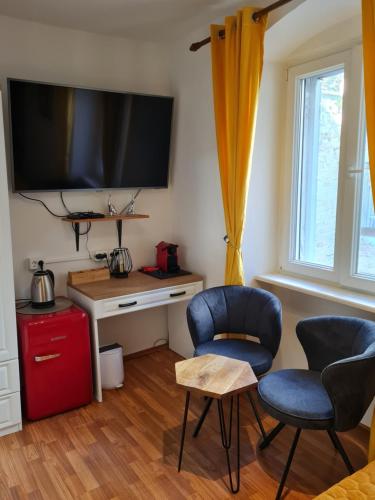 a living room with two chairs and a flat screen tv at INCHY ACCOMMODATION - in the center of Diocletian's Palace in Split
