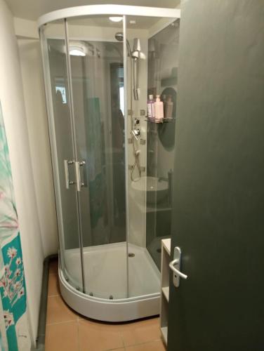 une douche avec une porte vitrée dans une salle de bain dans l'établissement 3 chambres pour 6 personnes, à Peyrilhac