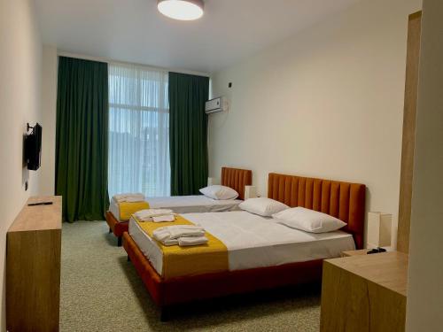 a hotel room with two beds and a window at Hotel Aeetes Kobuleti in Kobuleti