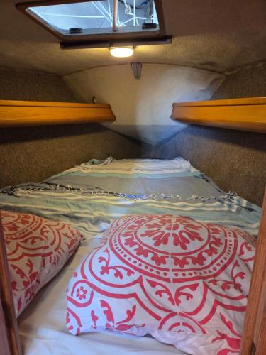 - un petit lit dans une petite maison avec fenêtre dans l'établissement Voilier atlantis, à Gruissan