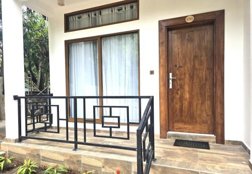 a front door of a house with a wooden door at Gatetrees resort in Jaffna