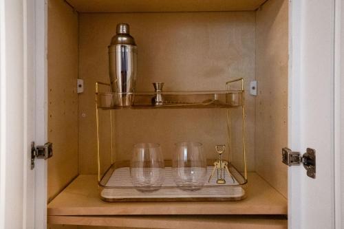 サマービルにある6BR3BATH Home with FREE Parking & Outdoor Furnitureの棚に空のワイングラスが4つ置かれたキャビネット