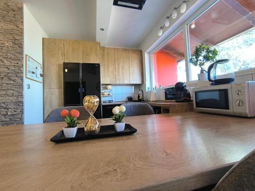 a kitchen with a wooden table with flowers and a trophy at Apartment Cedar Zagreb Airport - Velika Gorica in Ščitarjevo