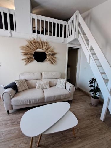 - un salon blanc avec un canapé et des escaliers dans l'établissement Appartement proche bord de mer, au Barcarès
