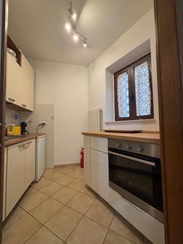 a kitchen with a stove and a window at Casa Al Vicolo in Seravezza