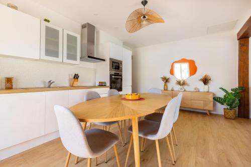 une cuisine et une salle à manger avec une table et des chaises en bois dans l'établissement OPALYS - Maison Plain Pied - Jacuzzi - Pétanque - Jardin - Parking - 800 m de la plage, à Berck-sur-Mer