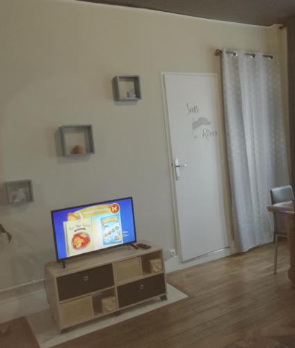 - une télévision assise sur un support dans le salon dans l'établissement LE KLEBER au choix VUE SUR PARC ou RUE simplicité d'accès, charme et confort garantis, à Troyes