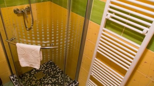 a shower with a glass door and a towel at Penzion Sidorovo in Ružomberok