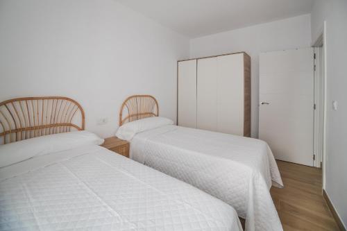 two beds sitting next to each other in a bedroom at Apartamento centro ciudad patio cuarenta 2A in Algeciras