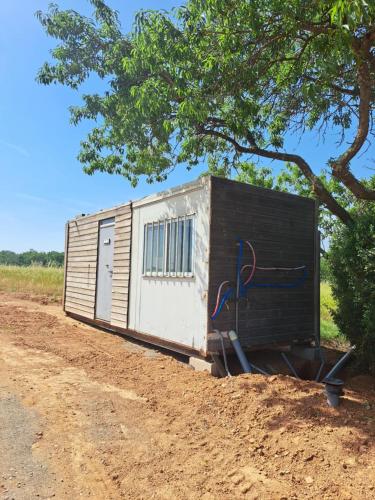 un petit hangar situé sur le côté d'un chemin de terre dans l'établissement Roulotte Ferme bio Campagne 66, à Thuir
