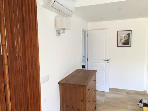 Cette chambre comprend une armoire en bois et un mur blanc. dans l'établissement Le Saint-Joseph, à Fréjus