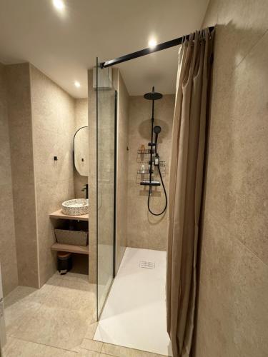 a shower with a glass door in a bathroom at Appartement 50m2, résidence privée avec piscine, tennis et à 100 m de la plage in Le Lavandou