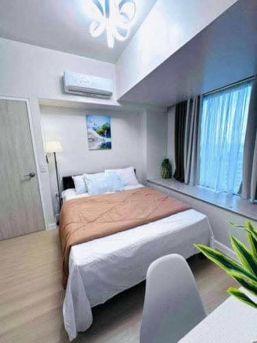 セブシティにあるGalleria Residences Towerの大きなベッドと窓のある寝室