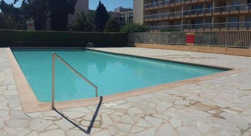 a swimming pool with blue water in a building at Appartement 50m2, résidence privée avec piscine, tennis et à 100 m de la plage in Le Lavandou