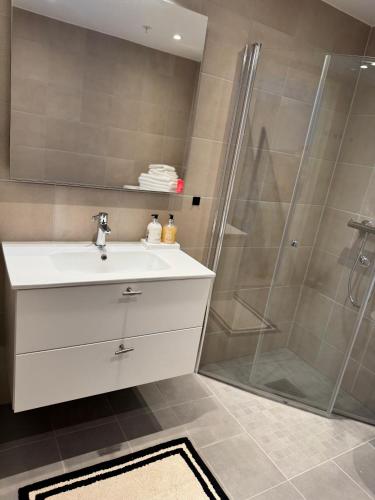 a bathroom with a sink and a shower at NORDIQ by the Fjord in Lii