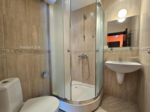 a bathroom with a shower and a toilet and a sink at Aпартаменти Хоризонт in Sozopol