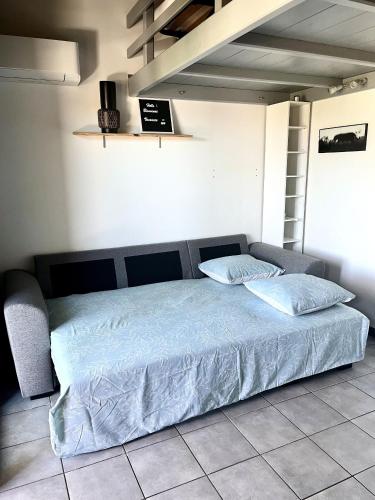 - un lit avec une couette bleue dans une chambre dans l'établissement Appartement proche des plages de sable, à Grosseto-Prugna