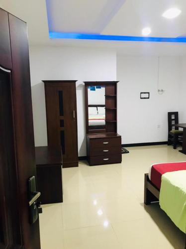 a bedroom with a bed and a dresser and a window at Laksara Grand Resort in Morawaka