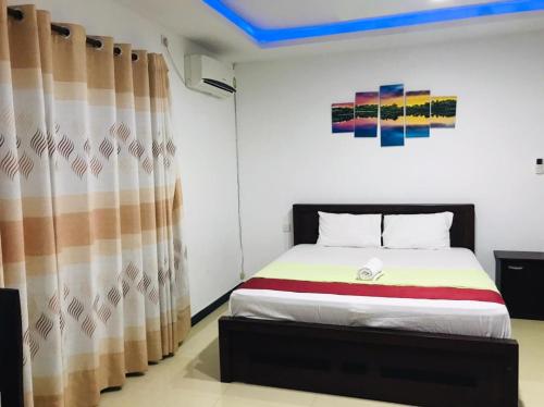 a bedroom with a bed and a curtain at Laksara Grand Resort in Morawaka