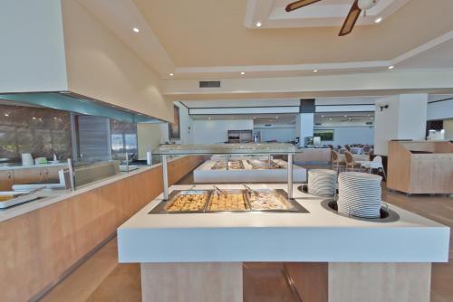 a restaurant with a counter with plates of food at Palmariva Beach Hotel in Eretria