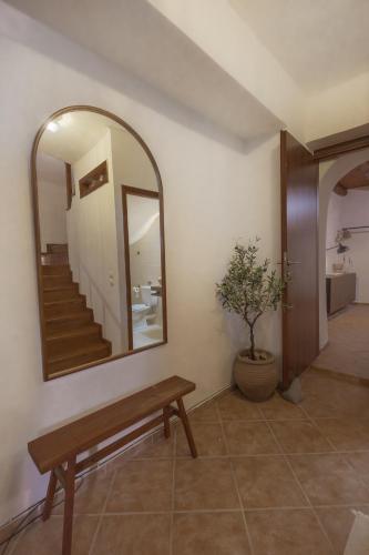 a mirror in a room with a bench and a staircase at The Yard Residence in Gavalochori