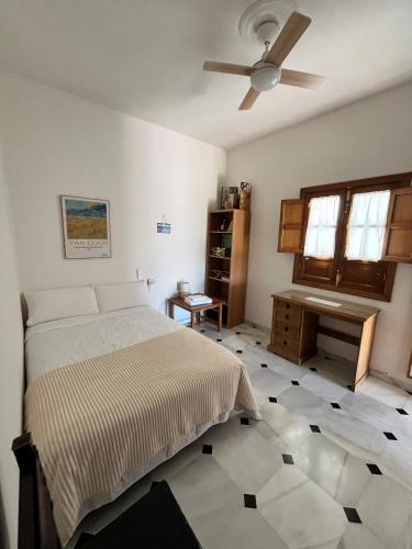 a bedroom with a bed and a ceiling fan at Casa Rural Oropesa in Villanueva del Ariscal