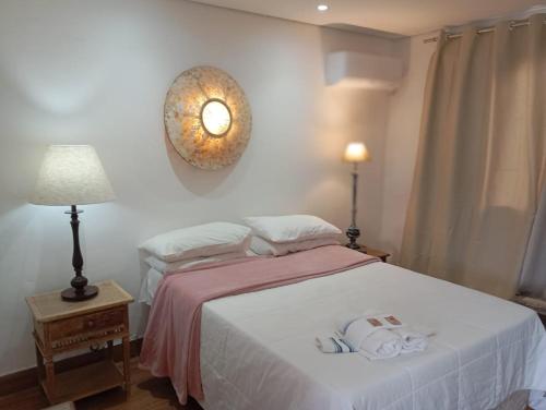 a bedroom with a bed and a clock on the wall at POUSADA CHARLOTTE in Tiradentes