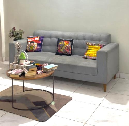 a living room with a gray couch and a table at Apna Adda for ladies only in Karachi