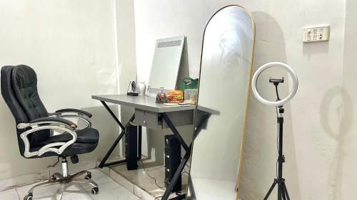 a desk with a chair and a surfboard in a room at Apna Adda for ladies only in Karachi